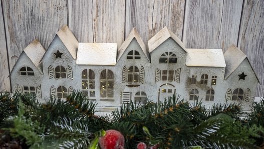 Metalowy świecznik siedem białych domków z szarymi dachami